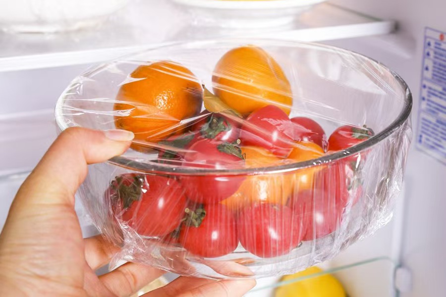 Transparent cling film covering a bowl of vegetables