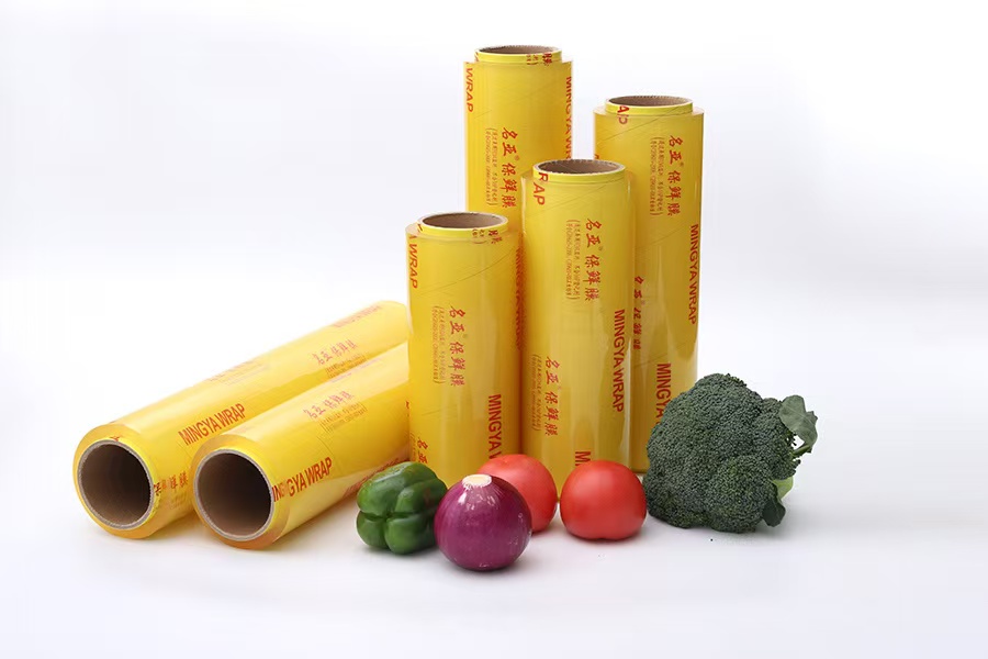 Packaged cling film rolls displayed with vegetables