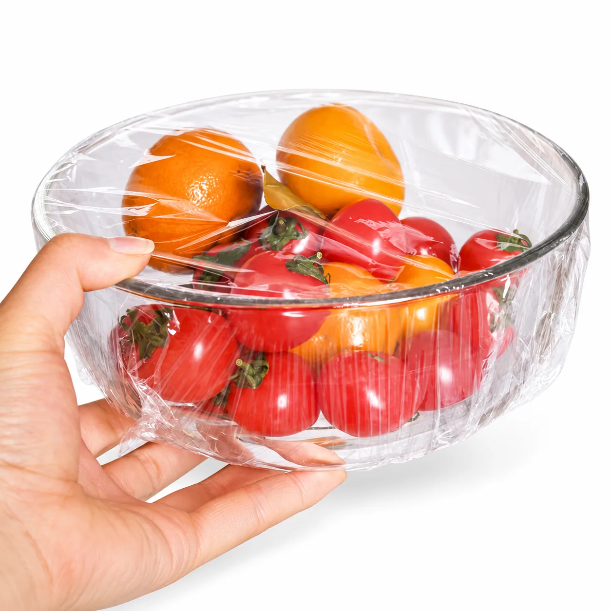 Transparent cling film covering a bowl of vegetables
