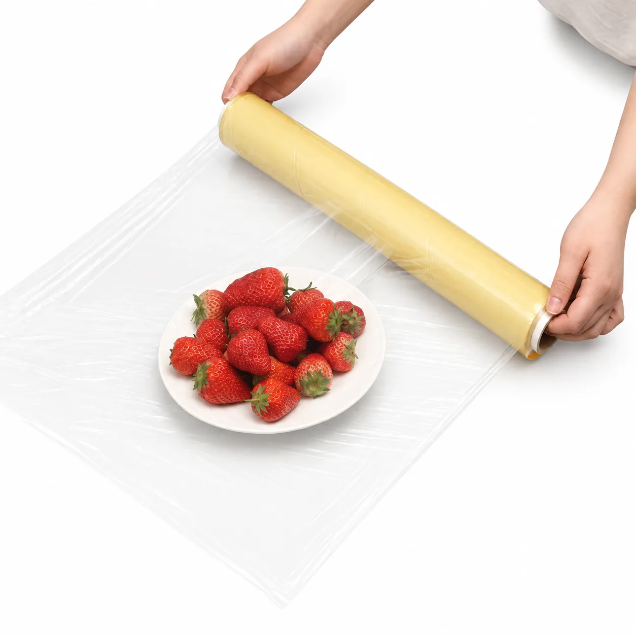 Hand wrapping a strawberry plate with transparent PVC film